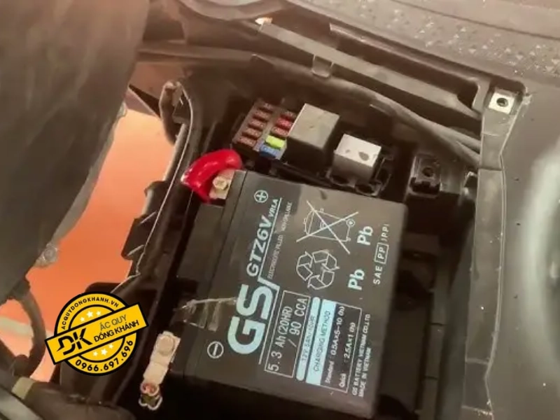 Sử dụng tua vít để tháo ốc cố định nắp bảo vệ ắc quy